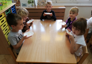 Zlizywanie miodku z talerzyka przez dzieci.