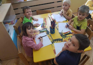 Dzieci z grupy drugiej kolorują kwiatki