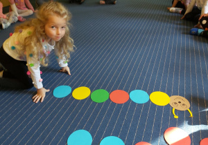 Dziewczynka układająca rytm z kolorwych kółek.