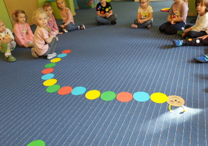Dzieci układające papierową gąsennicę tworząc rytm.