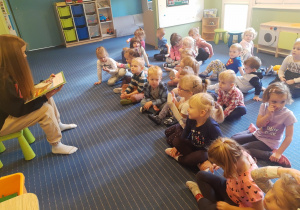 Dzieci z grupy I i II uważnie słuchają czytanej bajki.