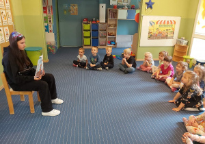 Dzieci z grupy II oglądają ilustacje z książki.