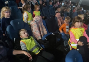Dzieci zajmują miejsca w kinie.