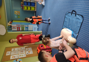Dziewczynka przymerza strój ratownika medycznego.