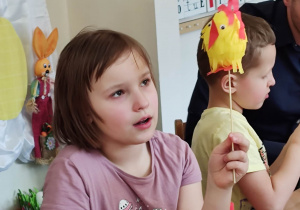 Dziewczynka pokazuje wykonanego kurczaczka na patyku.