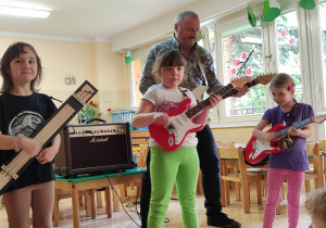 Dzieci występują wspólnie z gitarzystą.