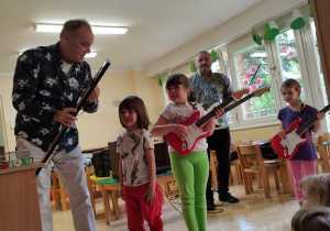 Dzieci występują wspólnie z gitarzystą.