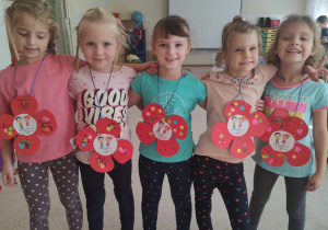 Dziewczynki pokazują wykonane własnoręcznie medale