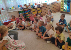 Dzieci słuchają czytanej książki.