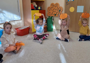 Dzieci w czasie zabawy z papierowymi dyniami.