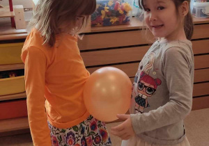 Dziewczyni w parze w czasie zabawy z balonem.