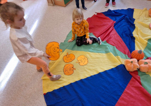 Dzieci w czasie zabawy z chustą animacyjną - układanie dyni na określonym kolorze.
