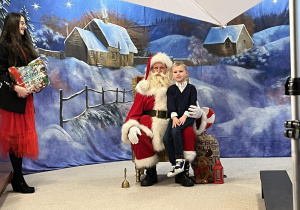 Mikołaj pozuje z dzieckiem do zdjęcia.