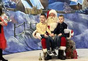 Mikołaj z dziećmi pozują do zdjęcia.