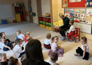 Dzieci słuchające bajki czytanej przez gościa.