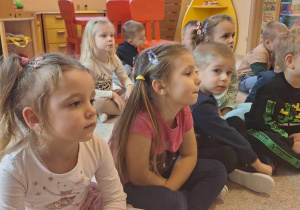 Przedszkolaki słuchające czytanej bajki.