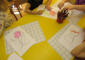 dzieci z gr. 2 kolorują kwiatki i muszki dla swoich bliskich.